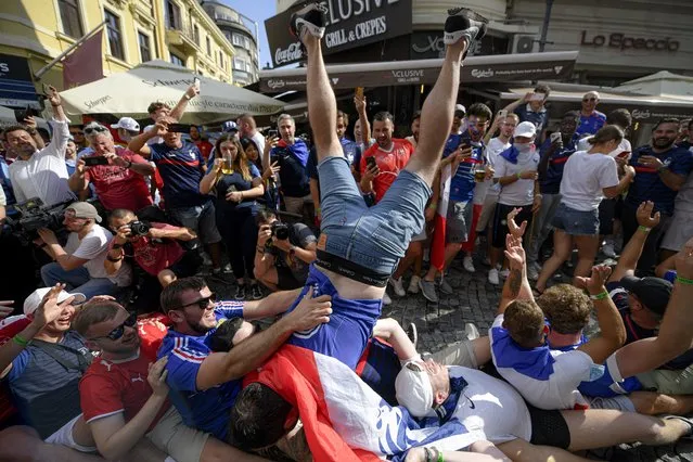 In this June 28, 2021, file photo, France's fans cheer prior to the Euro 2020 soccer championship round of 16 match between France and Switzerland in the old city district of Bucharest, Romania. Countries across Europe are scrambling to accelerate coronavirus vaccinations to outpace the spread of the delta variant in a high-stakes race to prevent hospital wards from filling up again with patients fighting for their lives. (Photo by Andreea Alexandru/AP Photo/File)