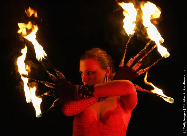 A fire dancer performs for crowds on the beach outside cafe Mambo in San Antonio