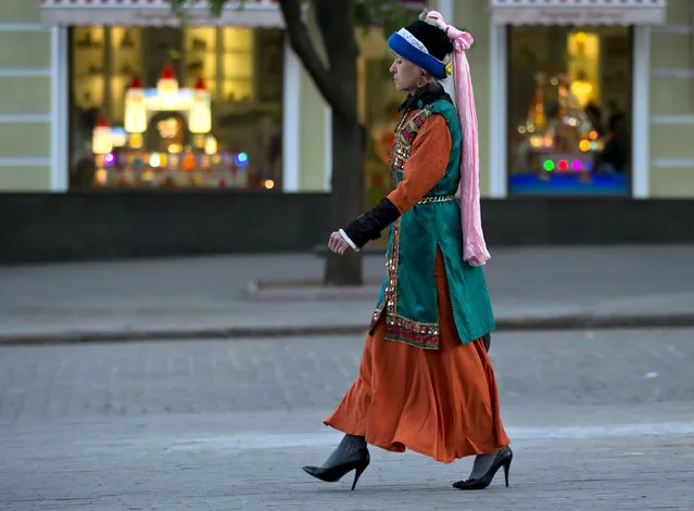 A woman walks, backdropped by the windows of a toy shop, in downtown Odessa, Ukraine, Tuesday, May 6, 2014. Odessa had been largely tranquil since the February toppling of President Viktor Yanukovych, until clashes erupted last Friday between pro-Russians and government supporters in the key port on the Black Sea coast, and left more than 40 people dead. (Photo by Vadim Ghirda/AP Photo)