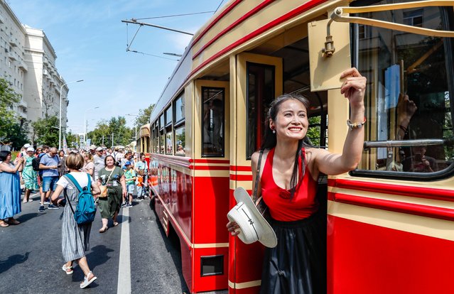 A woman adjusts the mirror of a retro tram KTM-1 (1948-1950) during the street exhibition “Retro Tram Parade” as part of marking the 125th anniversary of the city tramway service in Moscow, Russia on 13 July 2024. (Photo by Yuri Kochetkov/EPA/EFE)