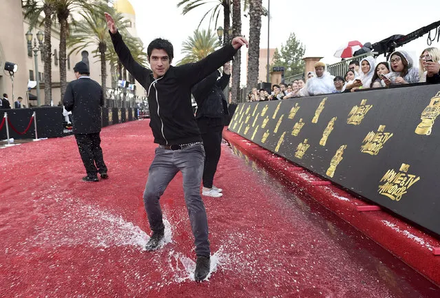 Tyler Posey slides on a soaked red carpet at the MTV Movie and TV Awards at the Shrine Auditorium on Sunday, May 7, 2017, in Los Angeles. (Photo by Jordan Strauss/Invision/AP Photo)