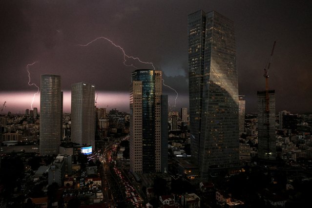 An Israeli flag is seen as lightning strikes over the sky in Tel Aviv, Israel, amid the ongoing conflict between Israel and the Palestinian Islamist group Hamas, in Gaza Strip on December 12, 2023. (Photo by Violeta Santos Moura/Reuters)