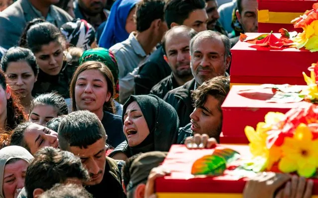 Syrian Kurdish mourners attend the funeral of victims of bombings two days ago in the northeastern city of Qamishli, on November 13, 2019. Three simultaneous bombings killed at least six civilians on November 11 in Qamishli, the latest attack to target the de-facto capital of the country's embattled Kurdish minority. There was no immediate claim of responsibility for the bombings, which came after the Islamic State group said it was responsible for the killing of a priest from the city. (Photo by Delil Souleiman/AFP Photo)