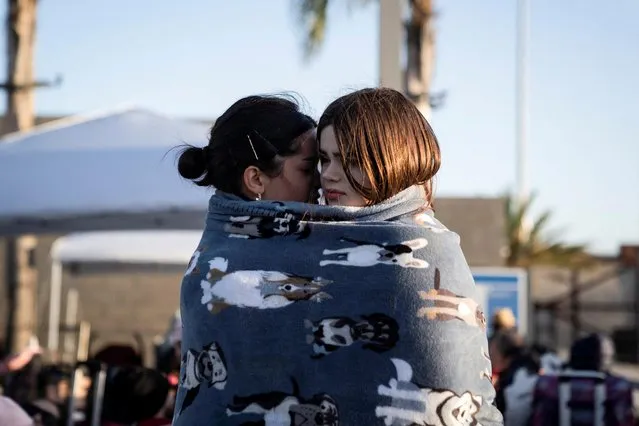 Two Ukrainian women seeking asylum in the U.S. embrace outside the San Ysidro Port of Entry in San Diego, California on April 12, 2022. (Photo by Toya Sarno Jordan/Reuters)
