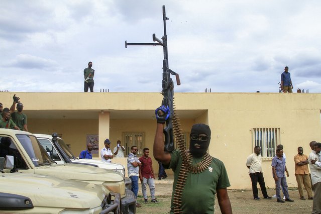 Members of a 'joint security cell' made up of various military and security services affiliated with Sudan's army, brandish rifles as they take part in a parade in Gedaref city in the east of the war-torn country, on July 28, 2024. Sudan has been gripped by war since April 2023, when fighting erupted between the army and the paramilitary Rapid Support Forces, killing tens of thousands, displacing millions and triggering one of the world's worst humanitarian crises. (Photo by AFP Photo)