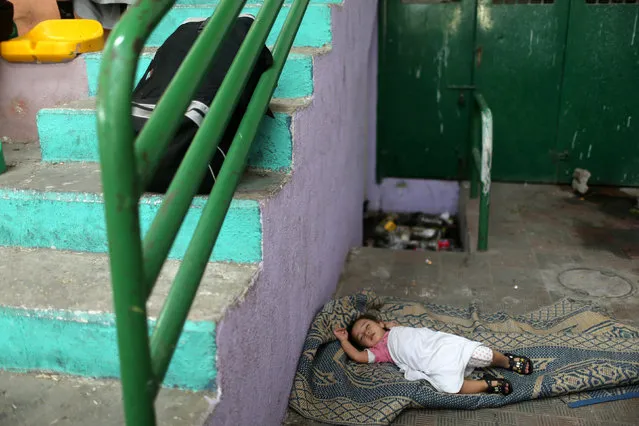 A girl sleeps as she waits with her family for a travel permit to cross into Egypt through the Rafah border crossing after it was opened by Egyptian authorities, in the southern Gaza Strip June 2, 2016. (Photo by Ibraheem Abu Mustafa/Reuters)