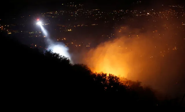 A helicopter flies over a hotspot while battling the “Old Fire” burning in Calabasas, California, U.S., June 4, 2016. (Photo by Mario Anzuoni/Reuters)