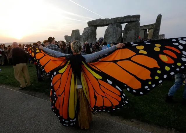 Reveler wearing butterfly wings waits for the sun to rise on the summer solstice during the annual festival at Stonehenge, Salisbury, Britain, 21 June 2017. (Photo by Kim Ludbrook/EPA)
