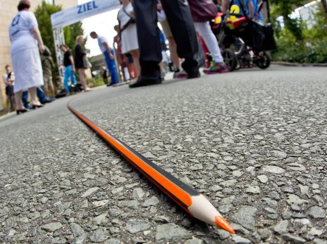 A more than 400 m long coloured pencil made by writing instrument manufacturer Staedtler pictured during a world record attempt in Nuremberg, Germany, 05 August 2015. With a total length of 459.97 m, the company was able to set a new record for the world's longest coloured pencil. (Photo by Daniel Karmann/EPA)