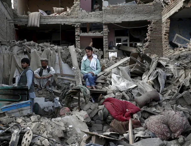 Men sit amid debris of their properties at the site a truck bomb blast in Kabul, August 7, 2015. Details were still unclear but the explosions took place near several potential targets, including a counternarcotics police camp near a base for U.S. security contractors and a U.S. special forces base known as Camp Integrity. (Photo by Ahmad Masood/Reuters)