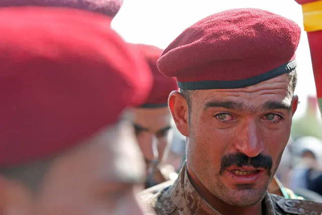 A fighter of Syrian Democratic Forces (SDF) mourns during the funeral procession of Kurdish fighters who were killed during clashes in the northeastern Syrian town of Ras al-Ain, in the town of Qamishli, Syria on October 22, 2019. (Photo by Muhammad Hamed/Reuters)