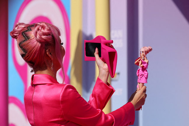 A fan takes a photo of a Barbie doll at the world premiere of the film “Barbie” in Los Angeles, California, U.S., July 9, 2023. (Photo by Mike Blake/Reuters)