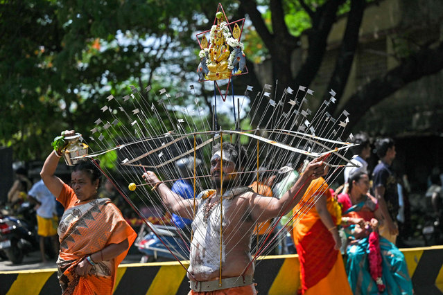 Devotees pierce their bodies with metal skewers during a religious procession to celebrate Aadi festival in Chennai on July 30, 2023. (Photo by R. Satish Babu/AFP Photo)