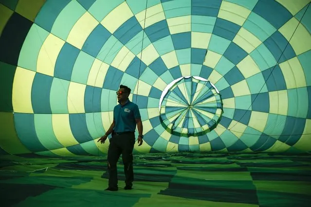 A staff memeber inspects the interior of a hot air balloon during the 2016 International Hot Air Balloon Festival in Taitung, southeast of Taiwan, 01 July 2016. 31 Hot-air balloon teams from 14 countries join the six days of competition during the festival, which will run from 01 July to 07 August 2016. (Photo by Ritchie B. Tongo/EPA)