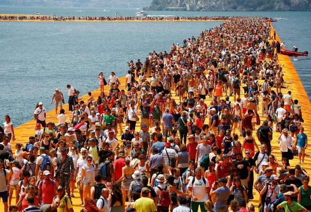 People crowd the installation “The Floating Piers” on Lake Iseo by Bulgarian-born artist Christo Vladimirov Yavachev, known as Christo, at the installation's last weekend near Sulzano, northern Italy, July 2, 2016. (Photo by Wolfgang Rattay/Reuters)