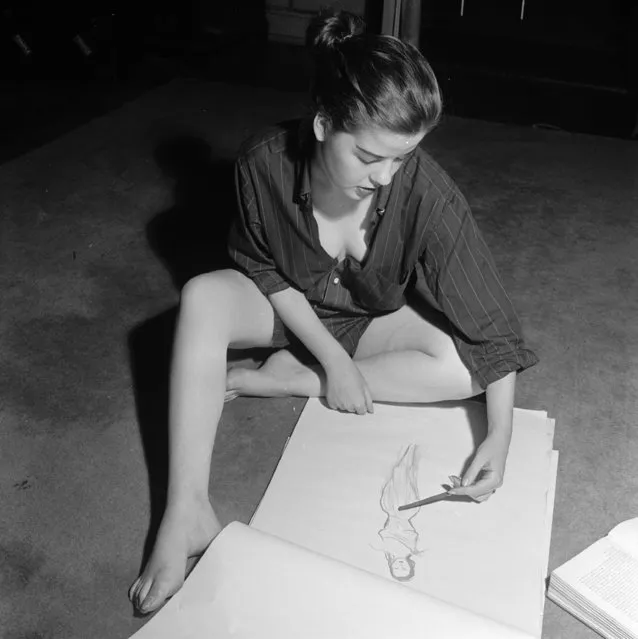 circa 1950:  A model designs a dress to wear to a party