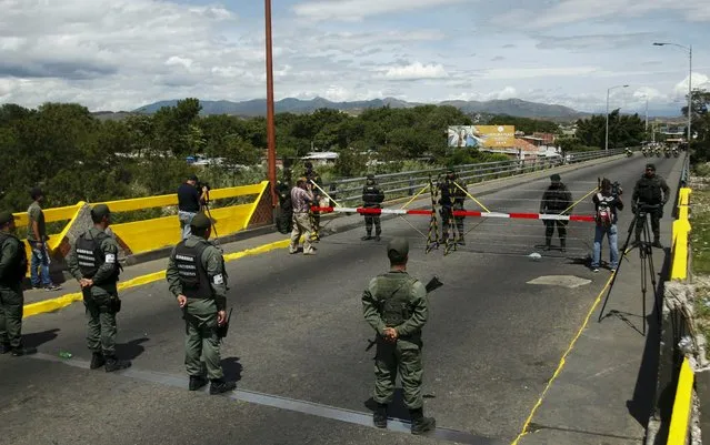 Venezuela's National Guards (bottom) stand in front of Colombia's soldiers at Simon Bolivar international bridge, on the border with Colombia, at San Antonio in Tachira state, Venezuela August 20, 2015. Venezuela's President Nicolas Maduro late Wednesday ordered two border crossings to Colombia closed for 72 hours after a shoot-out left three soldiers injured. (Photo by Carlos Eduardo Ramirez/Reuters)