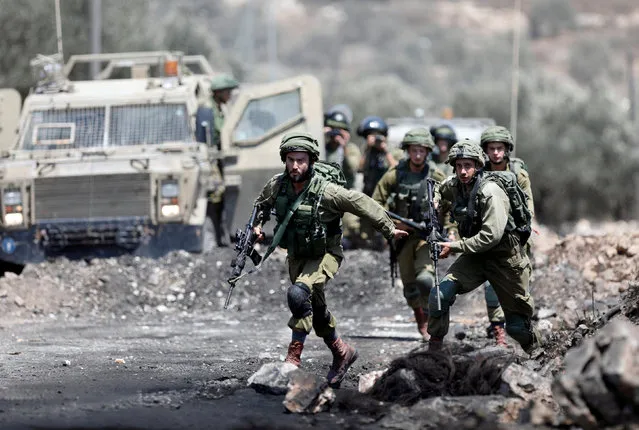 Israeli soldiers run during clashes with Palestinian protesters in the West Bank village of Kofr Qadom near Nablus August 18, 2017. (Photo by Mohamad Torokman/Reuters)