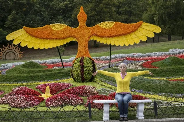 A visitor poses for a picture at a flower exhibition in Kiev, Ukraine, August 21, 2015. (Photo by Gleb Garanich/Reuters)