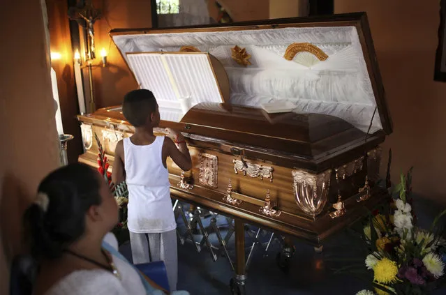 A boy looks at the coffin holding the body of Candido Rios Vazquez, a journalist for the Diario de Acayucan newspaper, who was murdered in Hueyapan de Ocampo in Veracruz state, Mexico, Wednesday, August 23, 2017. The National Human Rights Commission said that Rios was the ninth journalist slain so far this year in Mexico. Rios reportedly had been threatened repeatedly since 2012 by a former mayor of Hueyapan de Ocampo. (Photo by Felix Marquez/AP Photo)