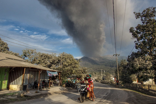 Villagers flee during an eruption of Mount Lewotobi Laki-Laki, a day after the previous eruption, in Boru Village, in East Flores, East Nusa Tenggara, on November 5, 2024. A volcano in eastern Indonesia erupted overnight, killing at least 10 people as it spewed fireballs and ash on surrounding villages, officials said on November 4 as they raised the alert to its highest level. (Photo by Arnold Welianto/AFP Photo)