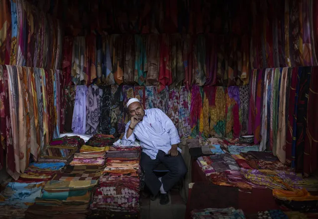 A Uyghur man waits for customers at his headscarf shop at a local market on August 2, 2014 in Kashgar, Xinjiang Province, China. (Photo by Kevin Frayer/Getty Images)