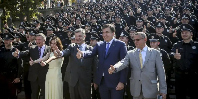 Ukrainian Interior Minister Arsen Avakov (2nd L) , First Deputy Interior Minister Eka Zguladze (3rd L), President Petro Poroshenko (C) and Governor of Odessa region Mikheil Saakashvili (2nd R) pose with newly graduated police officers during an oath-taking ceremony to launch the work of a new police patrol service, part of the Interior Ministry reform initiated by Ukrainian authorities in Odessa, August 25, 2015. (Photo by Markiv Mykhailo/Reuters/Ukrainian Presidential Press Service)