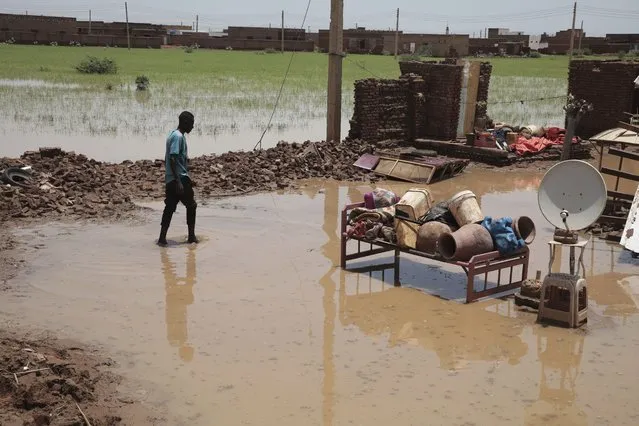 A man walks in water near what is left of his house after heavy rainfall in the village of Aboud in the El-Manaqil district of the Al-Jazirah province, southeast of Khartoum, Sudan, Tuesday, August 23, 2022. The death toll from flash floods in Sudan since the start of the country's rainy season has climbed to over 80, an official said Tuesday as the downpours continued to inundate villages across the east African nation. The United Nations said more than 146,200 people have been affected by floods. (Photo by Marwan Ali/AP Photo)