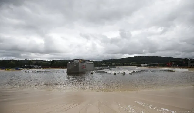 Surfers surf at Surf Snowdonia in Conwy, North Wales, September 3, 2015. (Photo by Andrew Yates/Reuters)