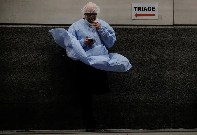 A doctor uses his phone outside the emergency center at Maimonides Medical Center during the outbreak of the coronavirus disease (COVID19) in Brooklyn, New York, April 14, 2020. (Photo by Brendan McDermid/Reuters)
