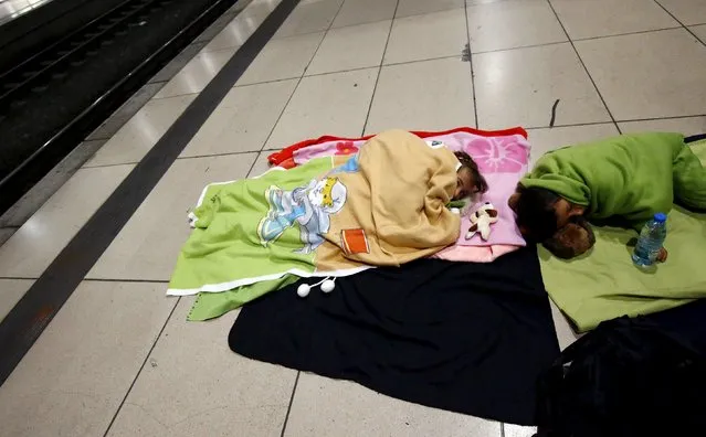 Two children of a Syrian family sleep on a platform after they arrived on a train from Budapest's Keleti station at the railway station of the airport in Frankfurt, Germany, early morning September 6, 2015. (Photo by Kai Pfaffenbach/Reuters)