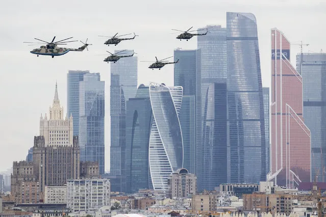 Russian military helicopters fly over Moscow's City skyscrapers and empty streets to mark the 75th anniversary of the Nazi defeat in World War II in Moscow, Russia, Saturday, May 9, 2020. A massive Victory Day parade on Red Square was cancelled due to the coronavirus outbreak, but Russia marked the holiday with the flyby. (Photo by Denis Tyrin/AP Photo)