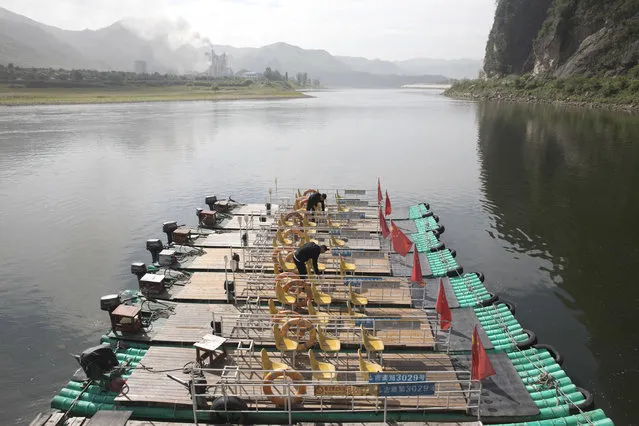 In this August 29, 2017 photo, Chinese men prepare rafts for tourists visiting the river that divides China from North Korea on the left near the Chinese city of Jian in northeastern China's Jilin province. Securing North Korea's missile launchers and nuclear, chemical and biological weapons sites would likely be a chief priority for China in the event of a major crisis involving its communist neighbor, analysts say, although Beijing so far is keeping mum on any plans. (Photo by Ng Han Guan/AP Photo)