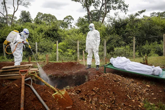 Members of a team dedicated to burying Muslim victims of the new coronavirus spray disinfectant into the grave before burying Mohamed Ali Hassan, whose cousin said had been unaware he had the new coronavirus and died in his house in the Eastleigh area, at the Langata Muslim cemetery in Nairobi, Kenya Thursday, May 7, 2020. The Kenyan government on Wednesday sealed off the Eastleigh area of the capital Nairobi and the Old Town area of the port city of Mombasa, with no movement permitted in or out for 15 days, due to “a surge in the number of positive coronavirus cases”. (Photo by Brian Inganga/AP Photo)