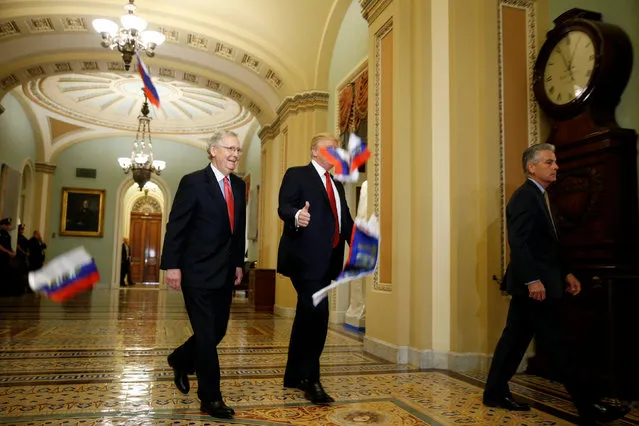 U.S. President Donald Trump gestures to reporters as Russian flags thrown from a protester fall in front of the president and Senate Majority Leader Mitch McConnell (R-KY) as they arrive for the Republican policy luncheon on Capitol Hill in Washington, U.S., October 24, 2017. (Photo by . (Photo by /Reuters)/Reuters)