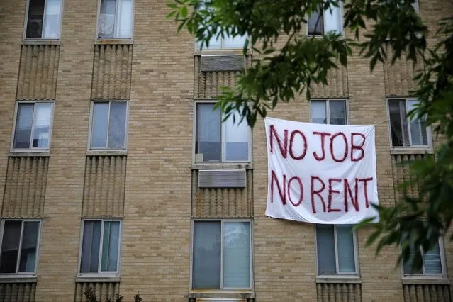 Makeshift sheets displaying messages of protest contesting the ability to pay for rent hang in the window of an apartment building in the Columbia Heights neighborhood in Washington, U.S., May 18, 2020. (Photo by Tom Brenner/Reuters)