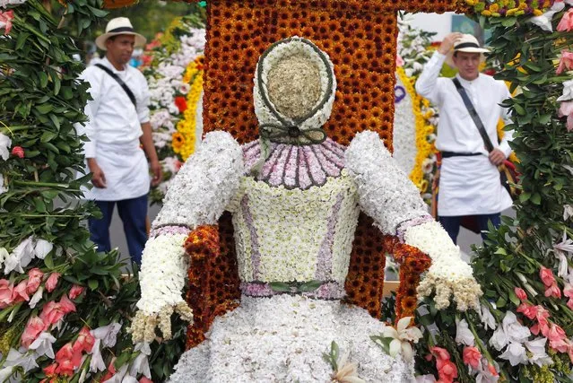 Flower growers known as “silleteros” stand near floral arrangements ahead of an annual flower parade in Medellin, Colombia, August 7, 2016. (Photo by Fredy Builes/Reuters)