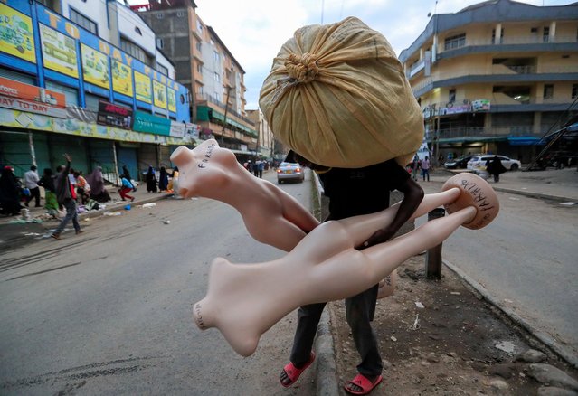 A trader carries his mannequins as he closes his business ahead of the lockdown restrictions set by the government to prevent the spread of the coronavirus disease (COVID-19), in Eastleigh district of Nairobi, Kenya on May 6, 2020. (Photo by Thomas Mukoya/Reuters)