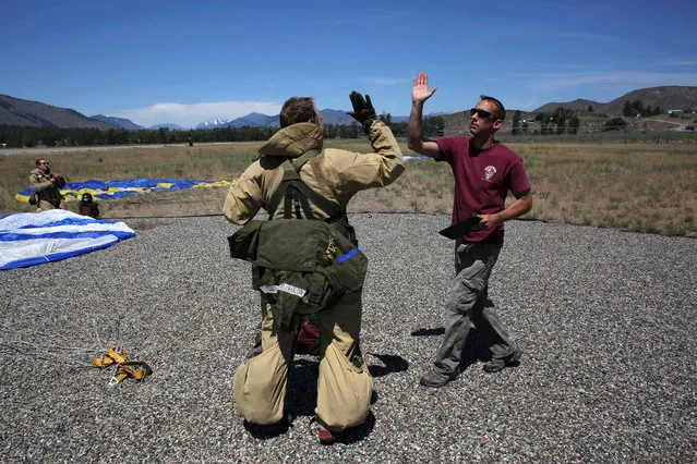 Smokejumpers celebrate a successful training jump at the North Cascades Smokejumper Base in Winthrop, Washington, U.S., June 6, 2016. (Photo by David Ryder/Reuters)