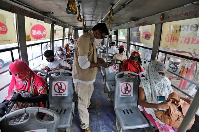 Indians board a city bus in Ahmedabad, India, Wednesday, June 10, 2020. India's coronavirus cases are spiking amid government reopening restaurants, shopping malls and religious places in most of its states after a more than 2-month-old lockdown. (Photo by Ajit Solanki/AP Photo)