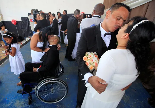 Couples kiss during a mass wedding ceremony, held for 17 male inmates, in the Carcel Villa Hermosa prison in Cali, Colombia, August 19, 2016. (Photo by Jaime Saldarriaga/Reuters)