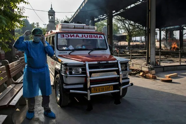 Mohammad Aamir Khan, an ambulance driver, waits for relatives to unload the bodies of people who died of the coronavirus disease for their cremation at a crematorium in New Delhi, India, June 11, 2020. (Photo by Danish Siddiqui/Reuters)