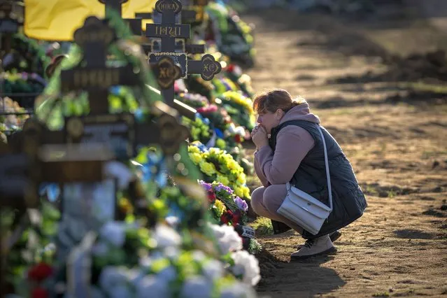 Tamara, 50, mourns at the grave of her only son, a military servicemen killed during a Russian bombing raid, at a cemetery in Mykolaiv, Ukraine, on Wednesday, October 26, 2022. Tamara did not learn of her son's death until four months after he died, when she managed to escape from her village in Kherson occupied by Russian troops. (Photo by Emilio Morenatti/AP Photo)