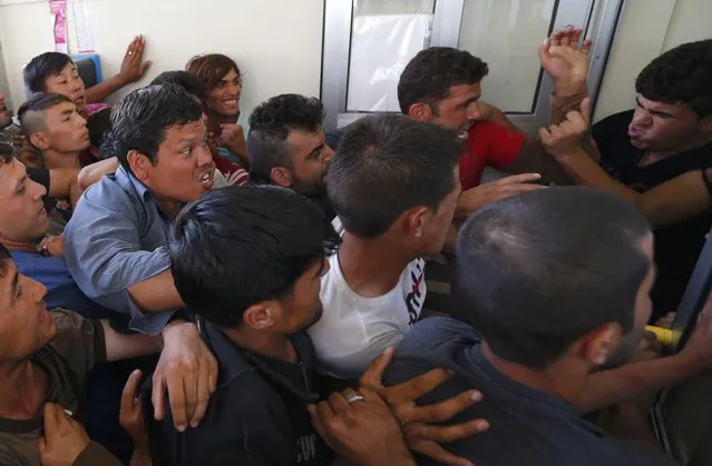 Migrants wrestle to buy train ticket at the train station in Beli Manastir, Croatia September 18, 2015. (Photo by Laszlo Balogh/Reuters)
