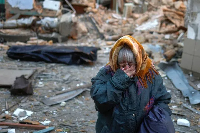 A woman reacts next to the body of her neighbour found under debris of a residential house destroyed by a Russian missile attack in Mykolaiv, Ukraine on November 1, 2022. (Photo by Valentyn Ogirenko/Reuters)