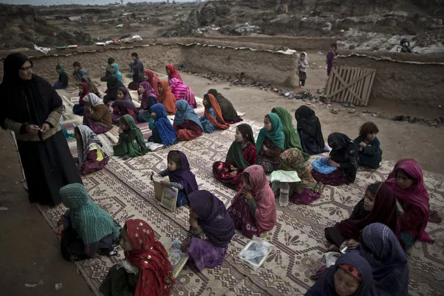 In this Tuesday, February 4, 2014, photo, Afghan refugee children repeat numbers displayed by their teacher during their class at a makeshift school set up in a mosque on the outskirts of Islamabad, Pakistan. (Photo by Muhammed Muheisen/AP Photo)