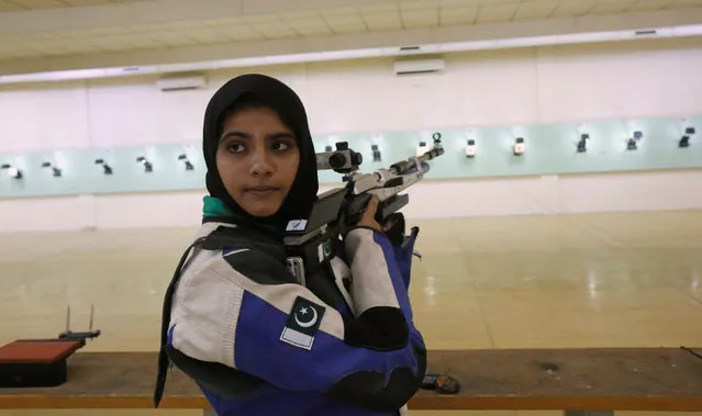 Minhal Sohail looks back as she prepares to shoot her air rifle during a practice session at the Pakistan Navy Shooting Range in Karachi, Pakistan, July 29, 2016. Picture taken July 29, 2016. (Photo by Akhtar Soomro/Reuters)