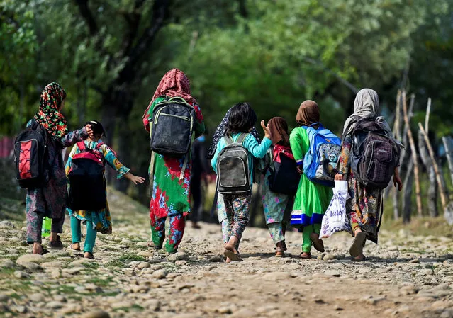 Schoolchildren walk towards their open-air school situated on top of a mountain in Doodhpathri, Indian-administered Kashmir, on July 28, 2020. Schooling in restive Kashmir has been severely disrupted by the pandemic, but also after a strict curfew was imposed almost a year ago when New Delhi stripped the Muslim-majority region of 14 million people of its semi-autonomy. (Photo by Tauseef Mustafa/AFP Photo)
