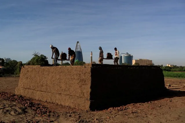 Mohamed Ahmed al Ameen (L), 55, and Mustapha (R), 60, who are both brick makers, prepare bricks to be fired in a kiln at an open-air factory on Tuti Island, Khartoum, Sudan, February 12, 2020. (Photo by Zohra Bensemra/Reuters)