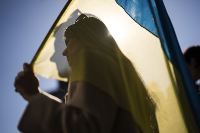 A woman holds a Ukrainian flag during a protest marking the second year of the invasion of Ukraine by Russia, in Istanbul, Turkey, Saturday, February 24, 2024. Ukraine is marking two years since Russia's full-scale invasion with a somber mood hanging over the country. On the battlefield, Ukrainian troops are running low on ammunition as they hope for further Western aid. (Photo by Francisco Seco/AP Photo)